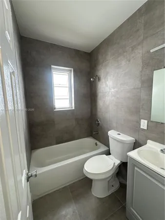 a white toilet sitting next to a bath tub