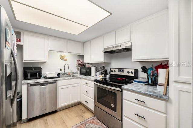 631 Silver Pass, Unit A Ocala, FL 34472 - Photo 20 of 47 a kitchen with white cabinets stainless steel appliances and sink