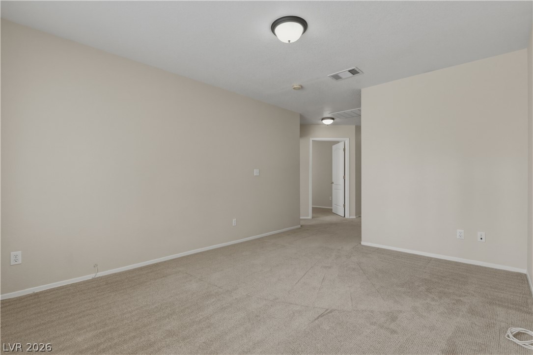 29 Olive Tree Henderson, NV 89074 - Photo 41 of 60 This spacious area offers endless possibilities for relaxation or activity, featuring neutral carpeting and clean walls.