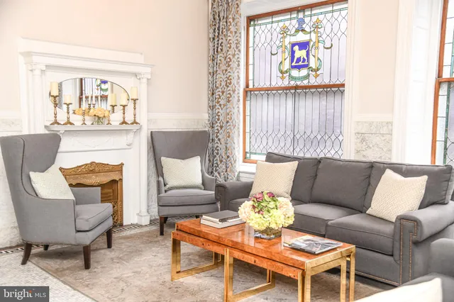 a living room with furniture a fireplace and a large window