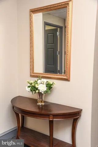 a view of a hallway with chair and wooden floor