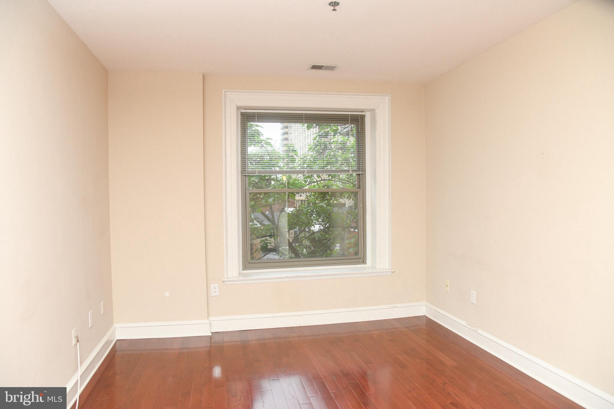 1811-19 Chestnut Street, Unit 404 Philadelphia, PA 19103 - Photo 6 of 17 an empty room with wooden floor and windows