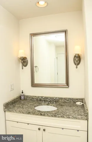 a bathroom with a granite countertop sink and a mirror