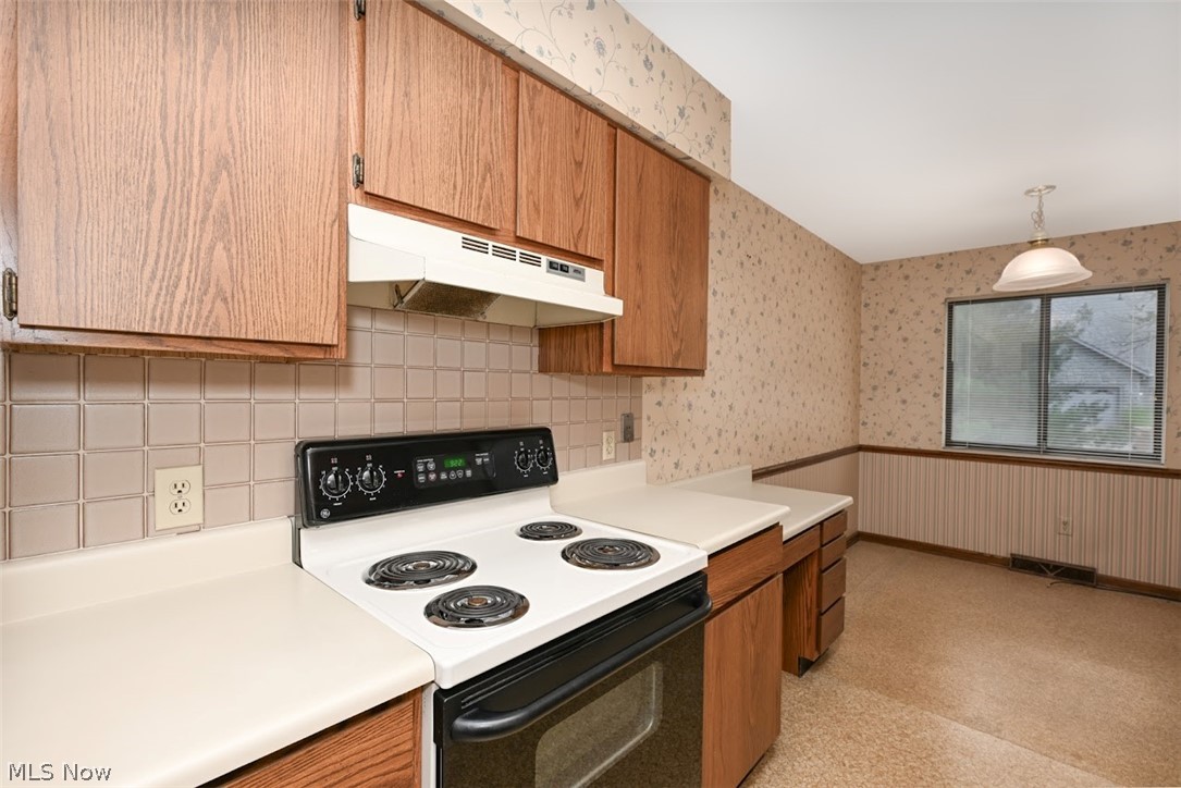979 Hampton Ridge Drive Akron, OH 44313 - Photo 12 of 25 Kitchen featuring hanging light fixtures, electric range, and tasteful backsplash