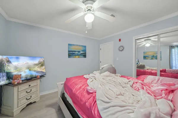 a bedroom with a bed and a chandelier fan