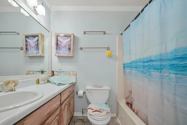 a bathroom with a granite countertop sink mirror vanity and toilet