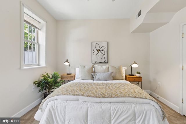 a bedroom with a bed and a potted plant