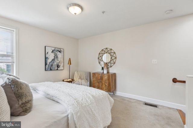 a bedroom with a bed and painting on the wall