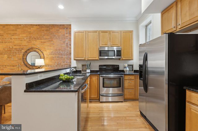 a kitchen with granite countertop a stove top oven microwave and refrigerator