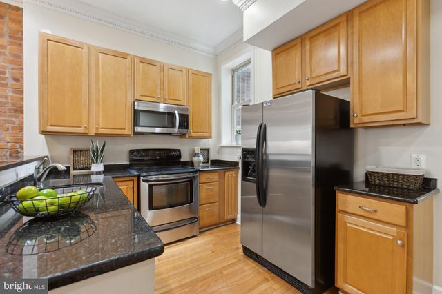 a kitchen with stainless steel appliances granite countertop a stove a refrigerator and a sink