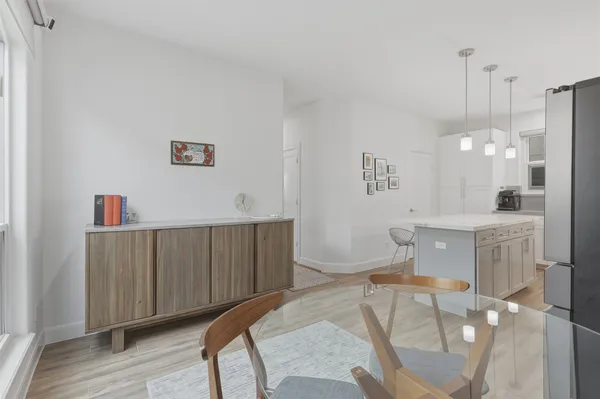 a spacious bedroom with a bed dresser and a wooden floor