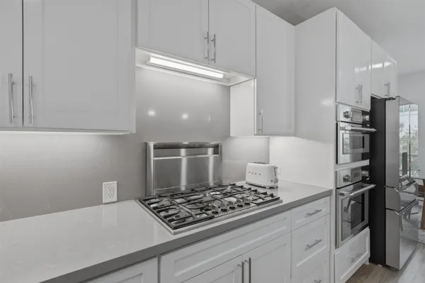 a kitchen with kitchen island a counter top space a sink stainless steel appliances and cabinets
