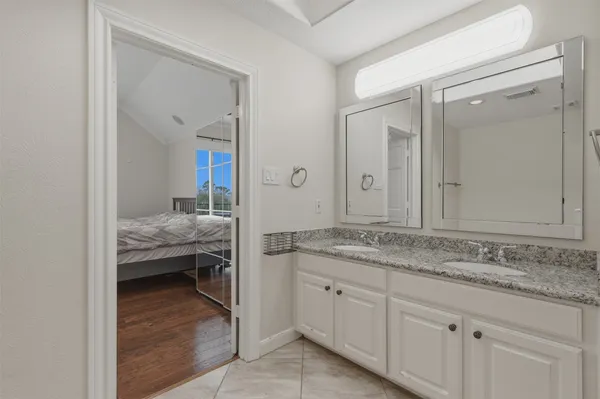 a en suite bathroom with a granite countertop sink and a mirror