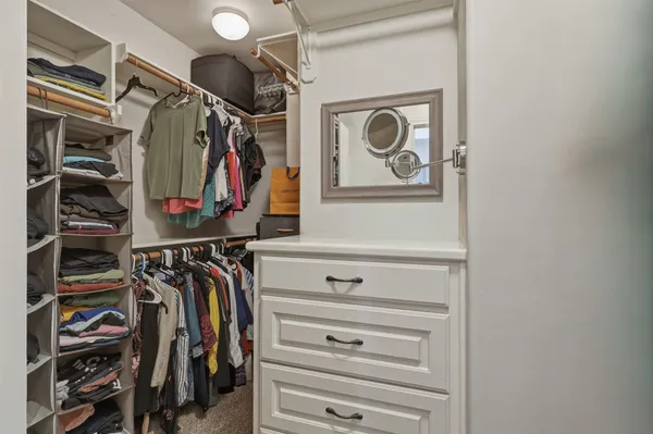 a view of walk in closet with clothes and shoes