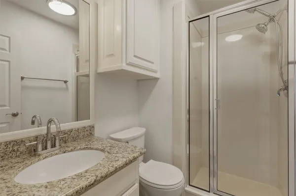 a bathroom with a granite countertop sink toilet and shower