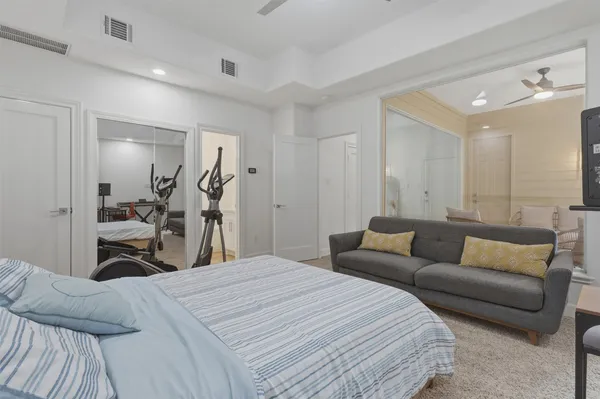 a bedroom with a bed and a large mirror