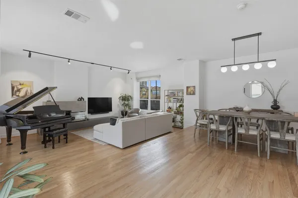 a living room with furniture a wooden floor and a piano