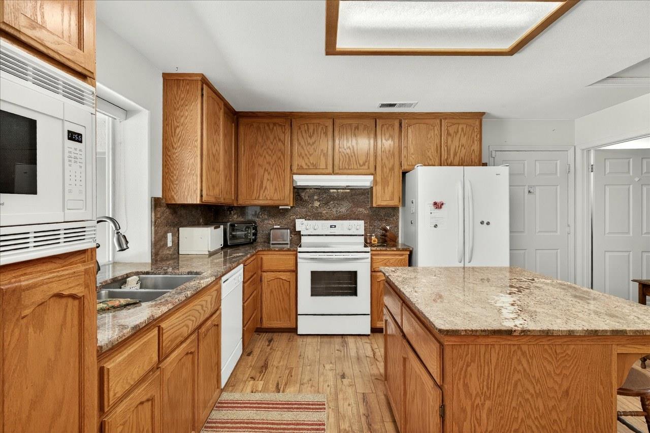 38090 Wortham Road Oakhurst, CA 93644 - Photo 18 of 54 a kitchen with a stove a sink and a refrigerator