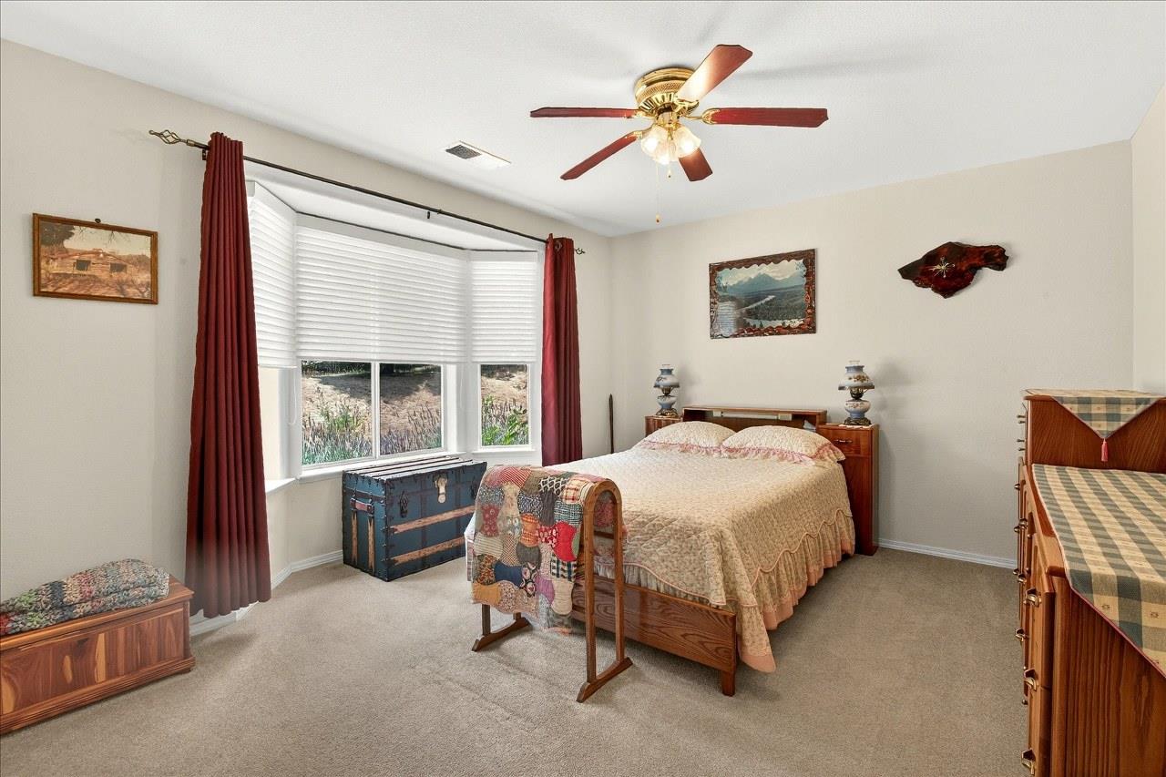 38090 Wortham Road Oakhurst, CA 93644 - Photo 26 of 54 a bedroom with a bed and a chandelier