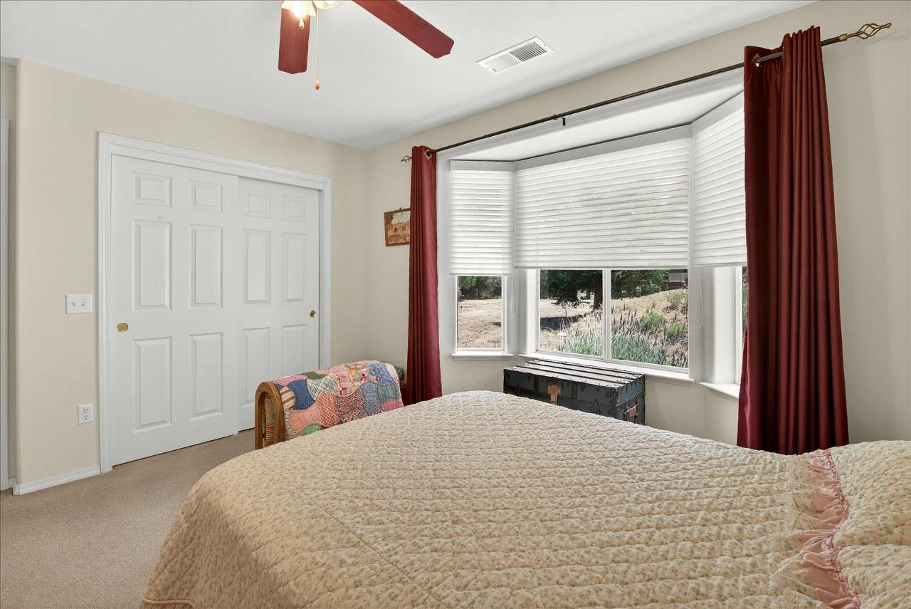 38090 Wortham Road Oakhurst, CA 93644 - Photo 27 of 54 a bedroom with a large bed and a large window