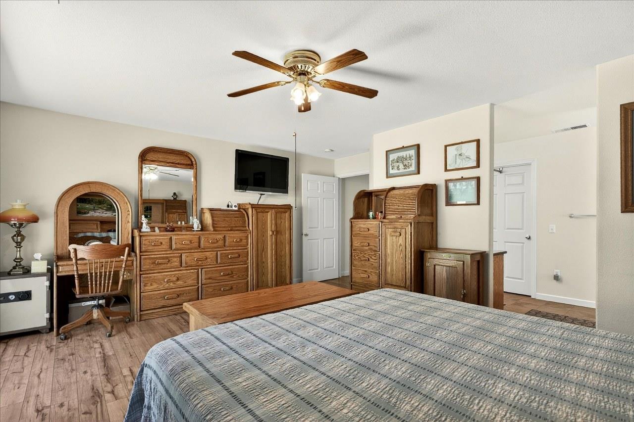 38090 Wortham Road Oakhurst, CA 93644 - Photo 29 of 54 a bedroom with a bed and dresser with wooden floor