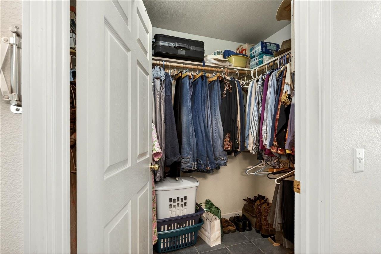 38090 Wortham Road Oakhurst, CA 93644 - Photo 30 of 54 a view of walk in closet with clothes and shoes