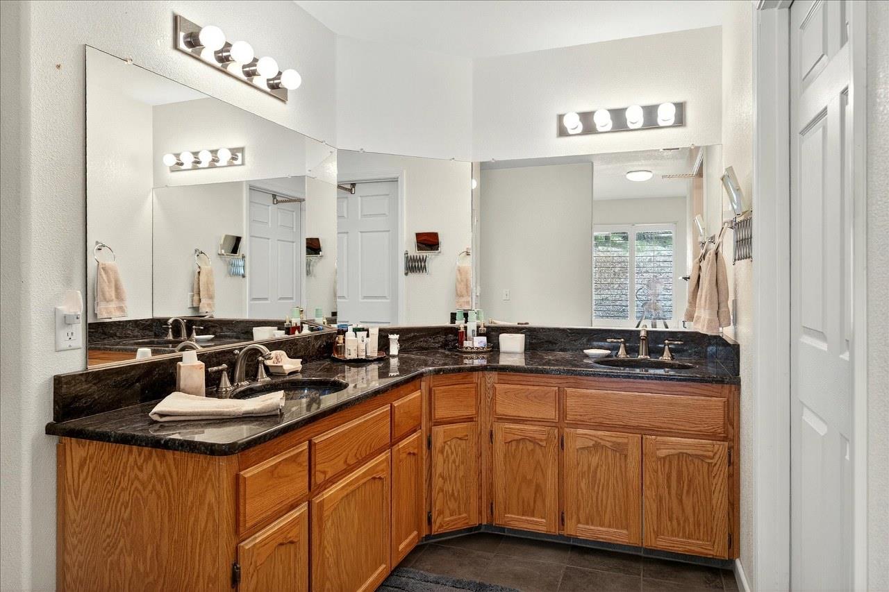 38090 Wortham Road Oakhurst, CA 93644 - Photo 31 of 54 a bathroom with sinks granite countertop a sink and a mirror