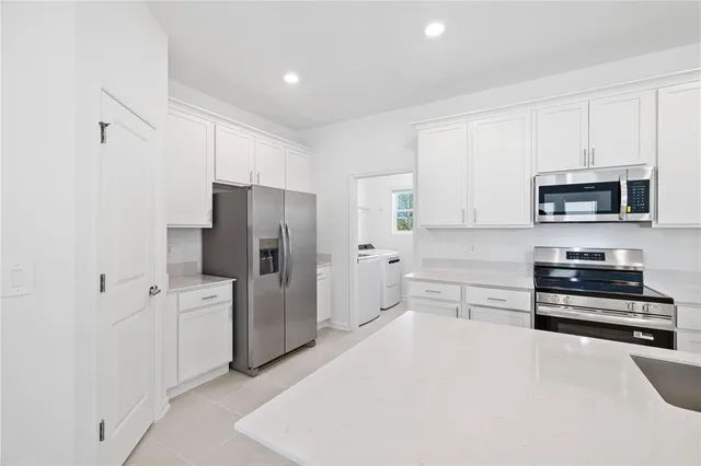 a kitchen with stainless steel appliances a refrigerator a stove a microwave and cabinets