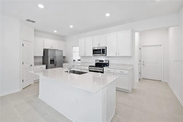 a kitchen with white cabinets and stainless steel appliances
