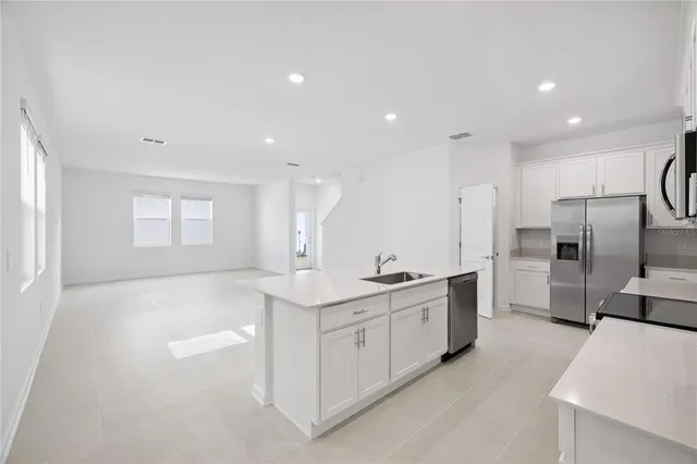 a kitchen with white cabinets and stainless steel appliances