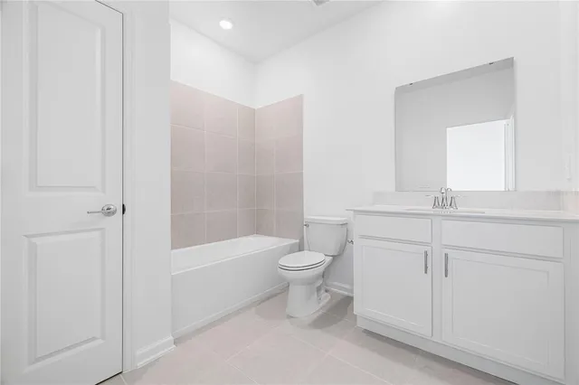 a bathroom with a toilet a sink a mirror and bathtub