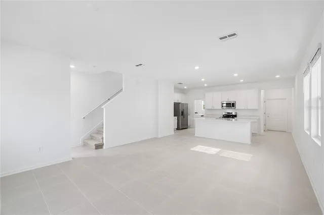 a view of a kitchen with refrigerator and white cabinets