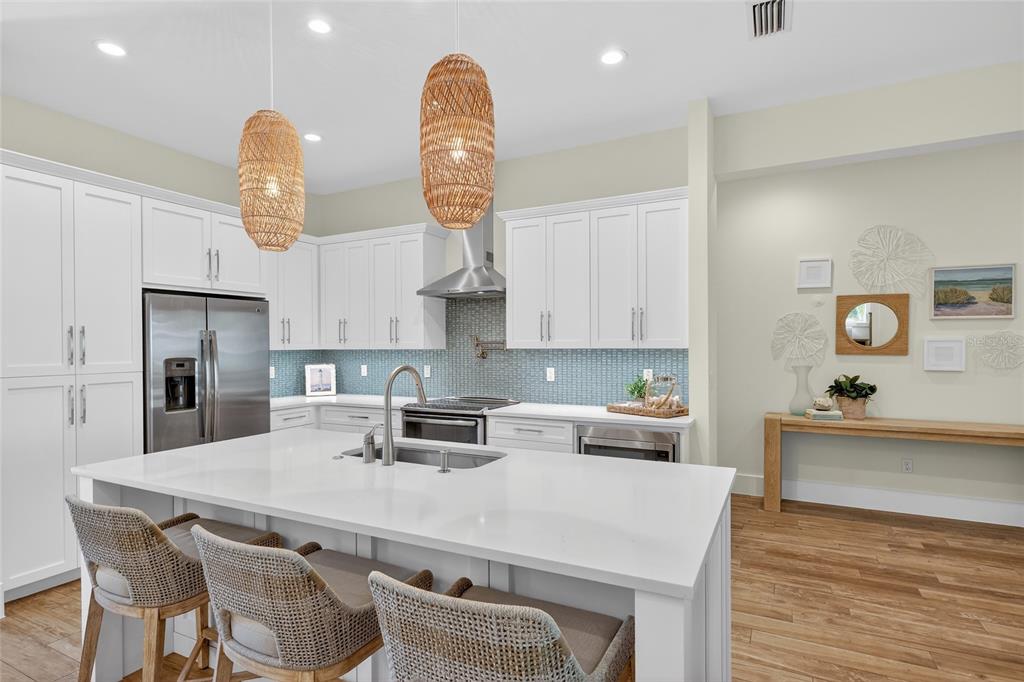 261 Seabreeze Court Boca Grande, FL 33921 - Photo 8 of 44 a kitchen with stainless steel appliances a table chairs and wooden floor
