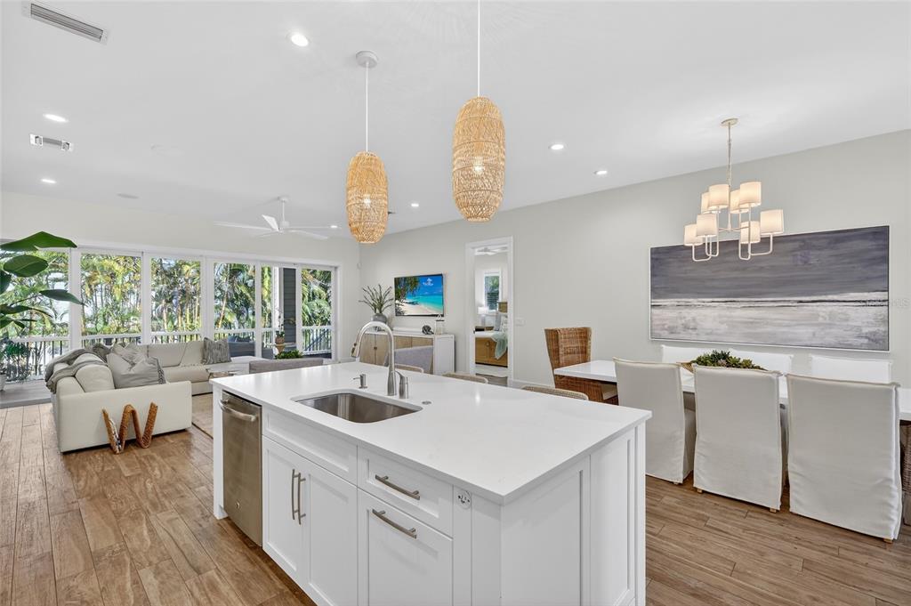 261 Seabreeze Court Boca Grande, FL 33921 - Photo 10 of 44 a kitchen that has a lot of white cabinets a sink and wooden floor