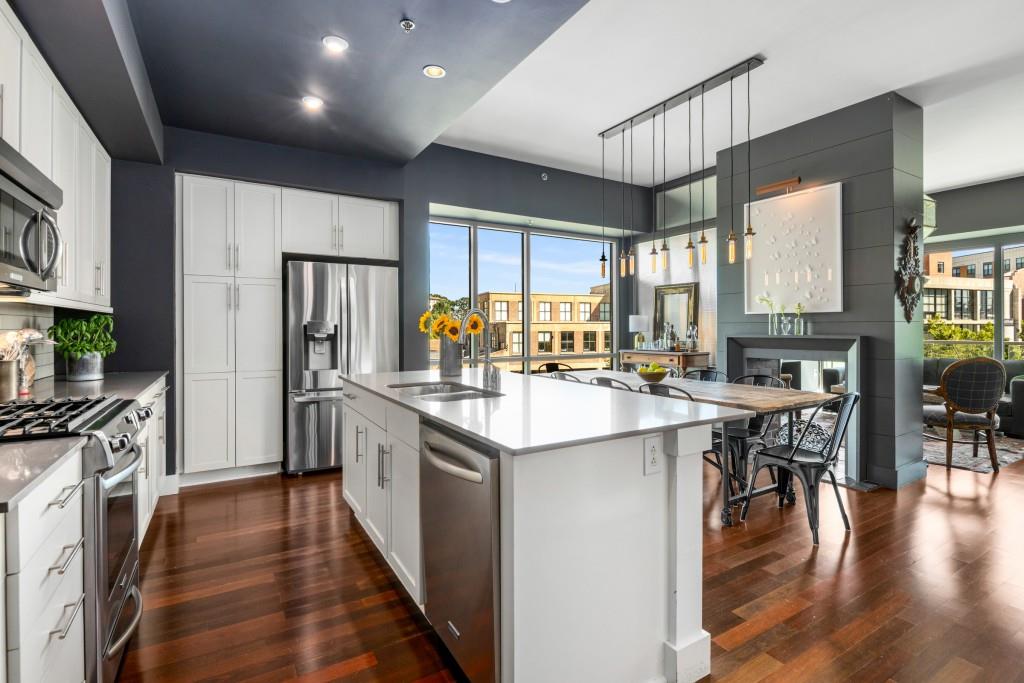 1100 Howell Mill Road Northwest, Unit 201 Atlanta, GA 30318 - Photo 1 of 50 a kitchen with stainless steel appliances granite countertop a refrigerator a sink dishwasher a stove and a dining table with wooden floor