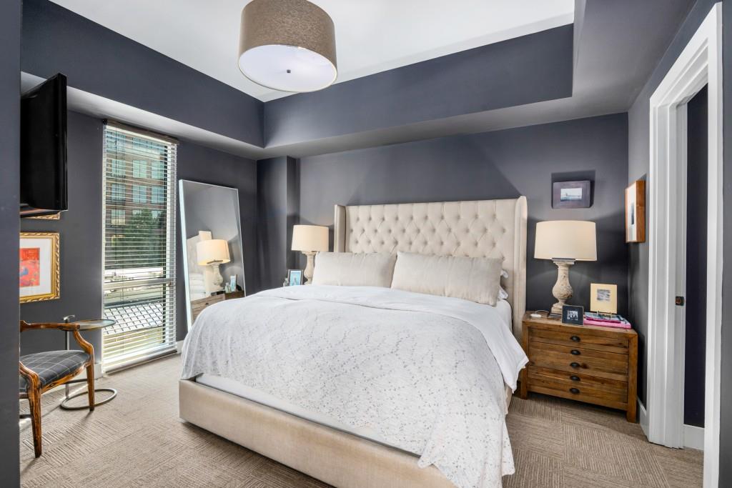 1100 Howell Mill Road Northwest, Unit 201 Atlanta, GA 30318 - Photo 9 of 50 a spacious bedroom with a large bed and a chandelier