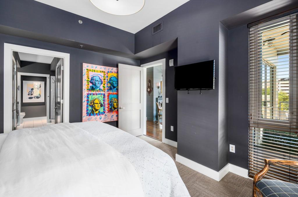 1100 Howell Mill Road Northwest, Unit 201 Atlanta, GA 30318 - Photo 10 of 50 a bedroom with a bed and a flat tv screen on dresser