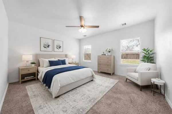 a spacious bedroom with a bed a couch and a window