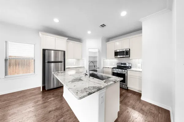 a kitchen with stainless steel appliances granite countertop a refrigerator stove microwave and sink