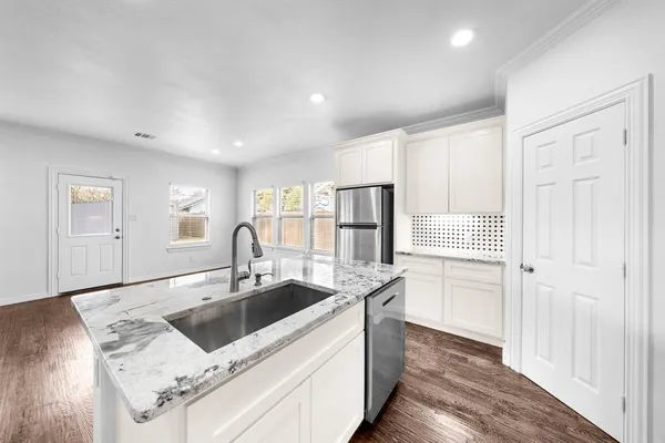 a kitchen with stainless steel appliances granite countertop a sink and a refrigerator