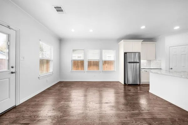 a view of empty room with wooden floor and window