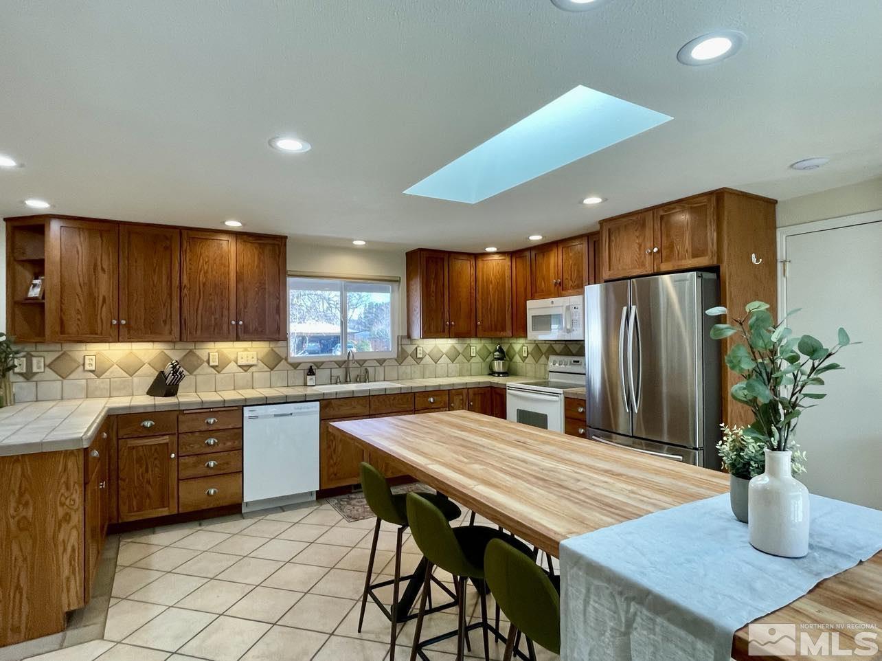 4001 Warren Way Reno, NV 89509 - Photo 8 of 28 a kitchen with stainless steel appliances kitchen island granite countertop a table chairs sink and cabinets