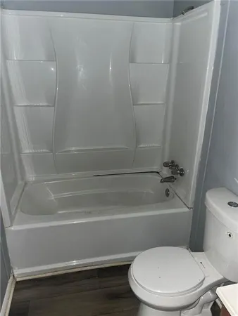 a toilet sitting next to a bath tub