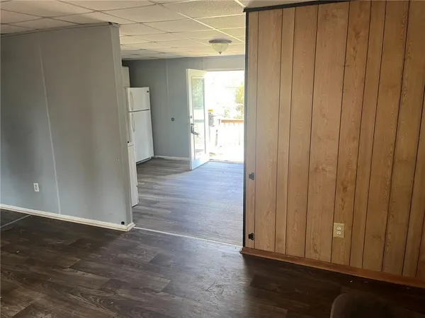 an empty room with wooden floor & windows