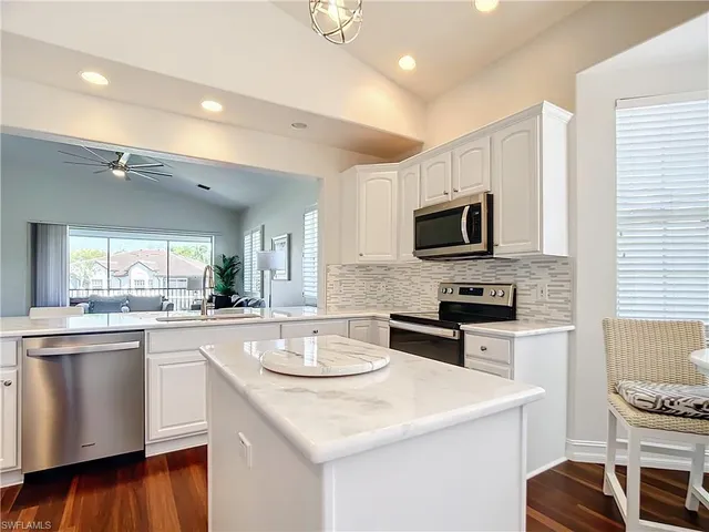 a kitchen with sink a microwave and cabinets