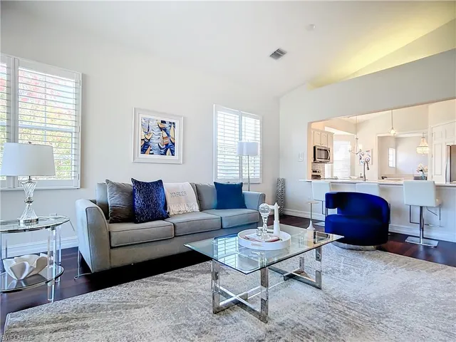 a living room with furniture a rug and a window