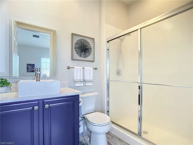 a bathroom with a granite countertop toilet sink and shower