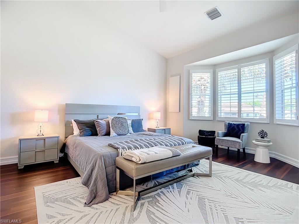 4752 Stratford Court, Unit 1404 Naples, FL 34105 - Photo 25 of 34 a bedroom with a bed and wooden floor