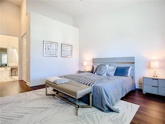 a spacious bedroom with a bed and wooden floor