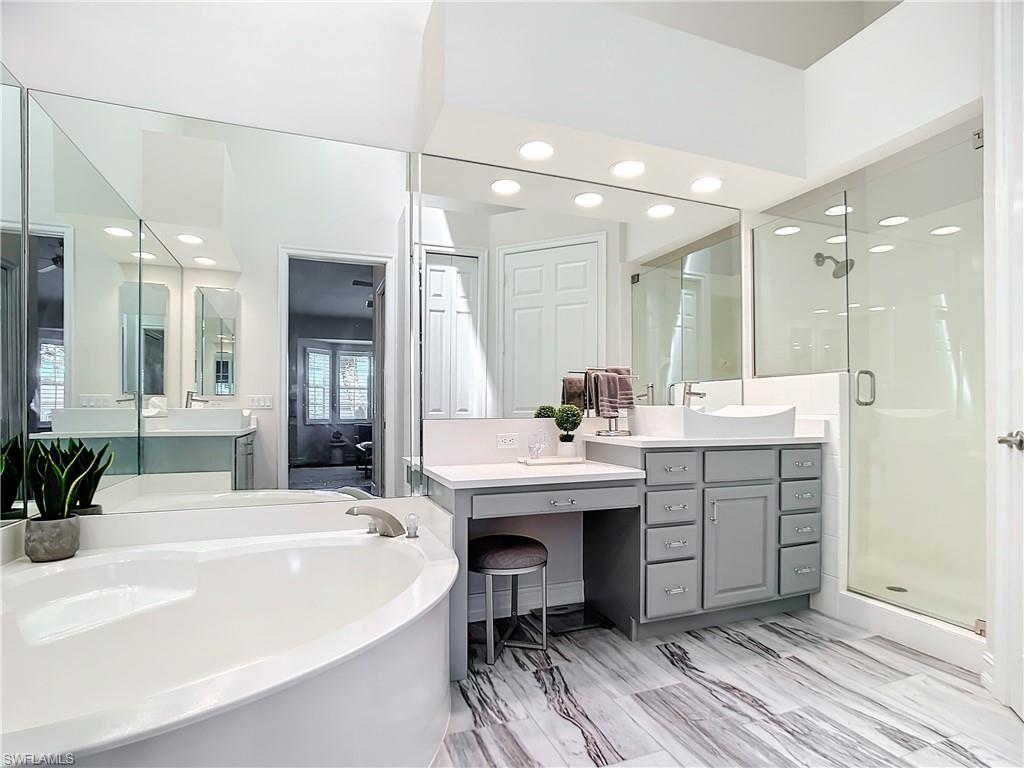 4752 Stratford Court, Unit 1404 Naples, FL 34105 - Photo 27 of 34 a bathroom with a sink double vanity granite tub and shower
